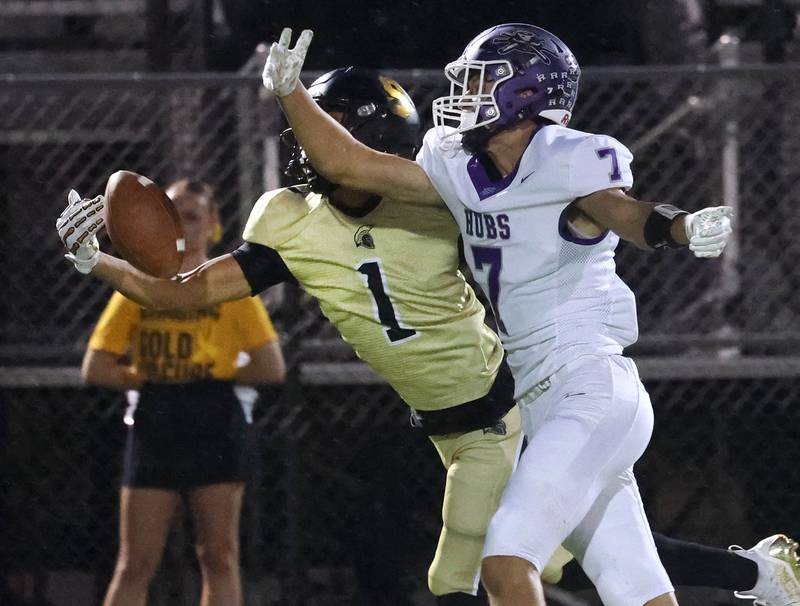 Sycamore's Josiah Mitchell comes up with a one-handed catch in front of Rochelle's Mark Green on Sycamore’s first play from scrimmage during their game Friday, Sept. 19, 2025, at Sycamore High School.