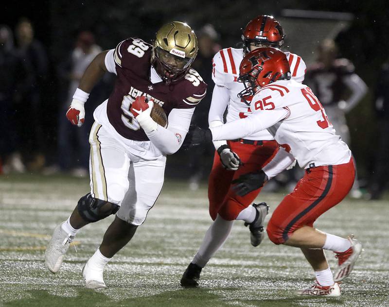 St. Ignatius' Guillermo Tapia runs wit the ball as Huntley's Carter Pope closes in during a IHSA Class 8A second round playoff football game on Friday, Nov. 3, 2023, at St. Ignatius College Prep in Chicago.