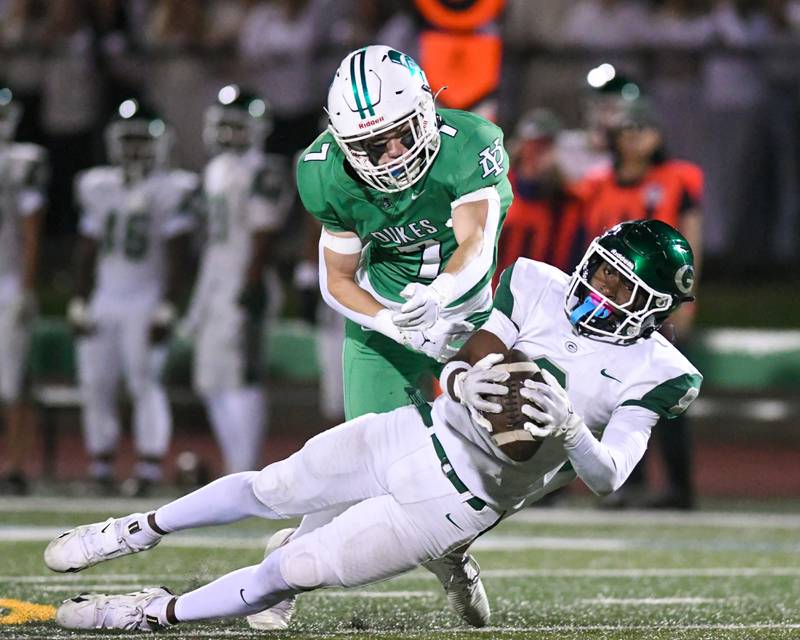Glenbard West's Jaylen McMiller (9) catches the ball for a first down during the game while being defended by York's Drew Richardson (7) on Friday Oct. 17, 2025, held at York High School.