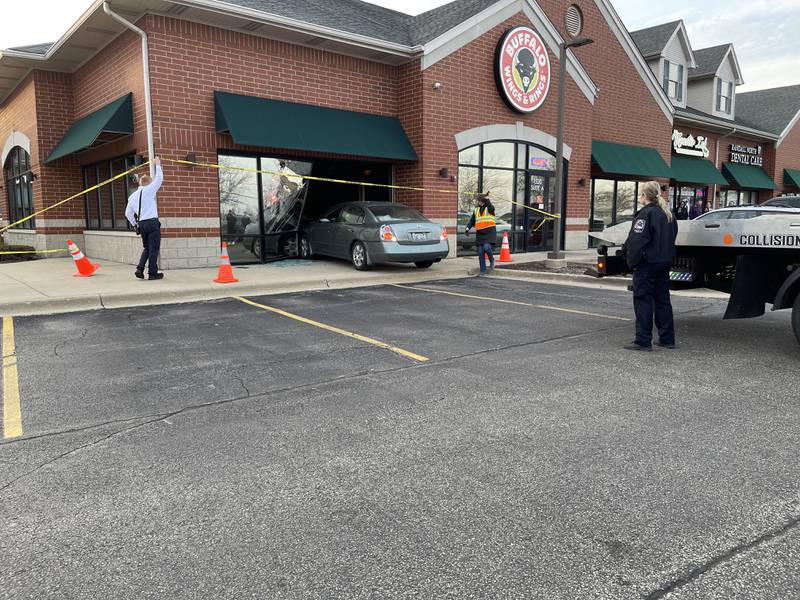 Officials back a Nissan Altima out of a building that it crashed into on Thursday evening, March 23, 2023.