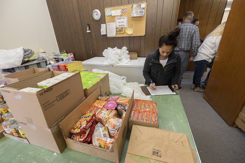 Food pantry volunteer Lovely Macklin checks off items Monday, Jan. 29, 2024 in Dixon.