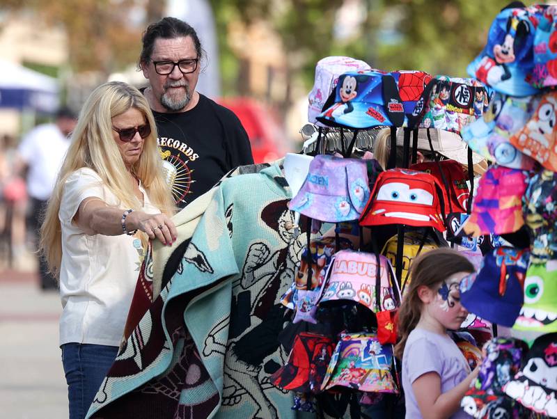 Dean Gunter and Serinity Meadows, from Carbondale, check out some of the items at the craft show Friday, Aug. 22, 2025, during the first day of Corn Fest in downtown DeKalb.