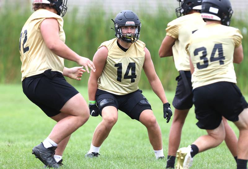 Sycamore's Kiefer Tarnoki (middle) blitzes the quarterback Monday, Aug. 8, 2022, at the school during their first practice ahead of the upcoming season.