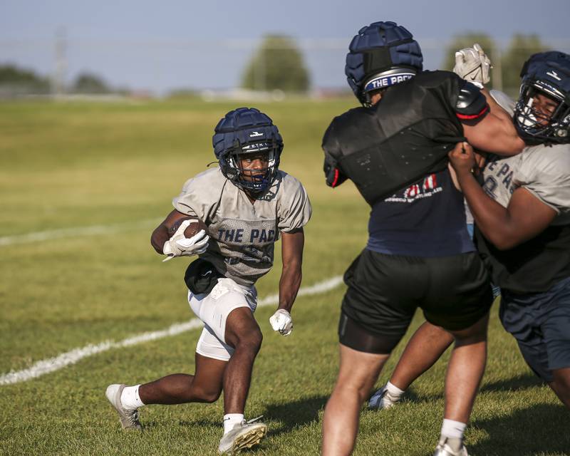 Jasaih Watson runs up the middle in a live scrimmage at Oswego East  High School football practice, Monday, Aug 13, 2025 in Oswego.
