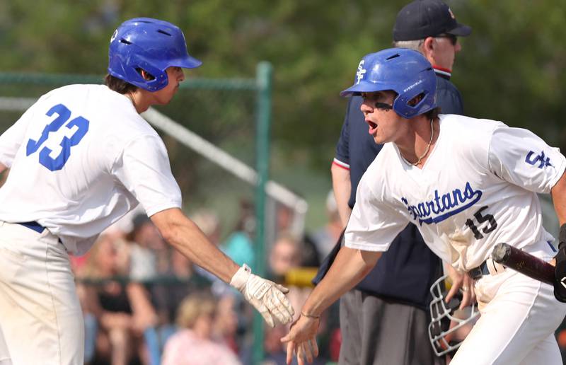 St. Francis' Luc Swiatek (right) is congratulated after scoring the games first run by Jake Castaldo in their Class 3A regional semifinal against Sycamore Thursday, June 1, 2023, at Kaneland High School in Maple Park.