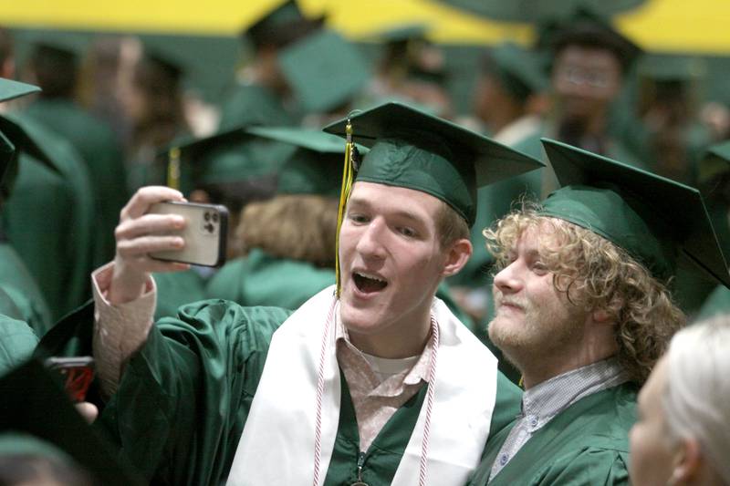Cary Lorentz, left, takes a picture with Cam Pierce as they prepare to line up for graduation at Crystal Lake South High School in Crystal lake on Saturday, May 17, 2025.