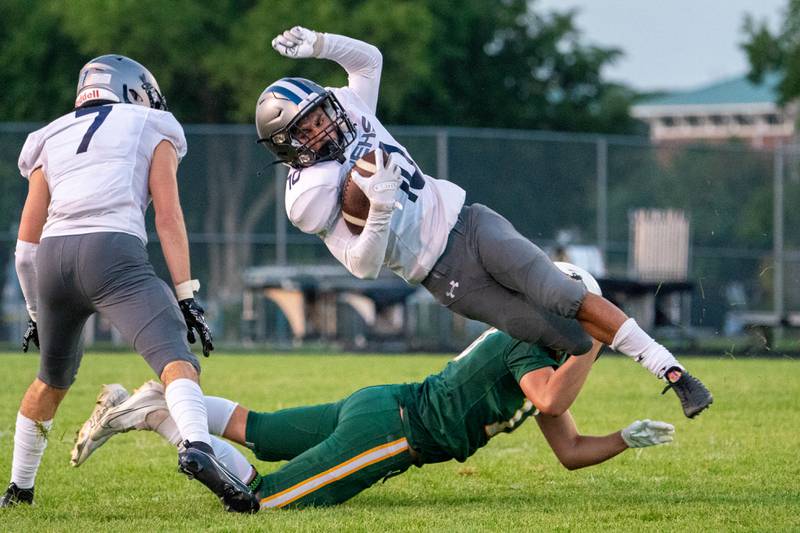 Oswego East's Tyler Stamatis is tackled by Waubonsie Valley's Joshua Tinney after the catch during a football game at Waubonsie Valley High School in Aurora on Friday, Aug. 25, 2023.