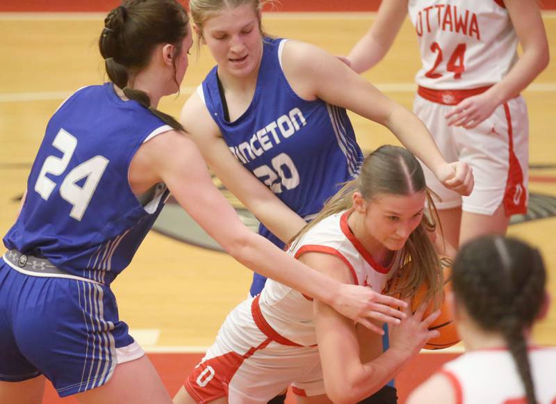 Ottawa's Hailey Larsen grabs a rebound in the lane over Princeton's Keighley Davis and teammate Reese Reviglio on Monday, Feb. 3, 2025 in Kingman Gymnasium at Ottawa High School.