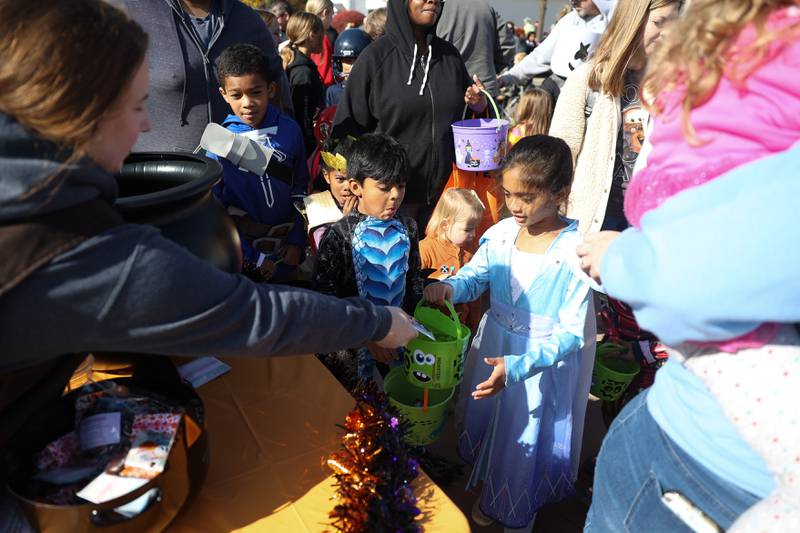 A little girl gets candy from the CoCo Marie’s table at the annual Halloween Spooktacular in downtown Plainfield on Saturday, Oct. 28, 2023.