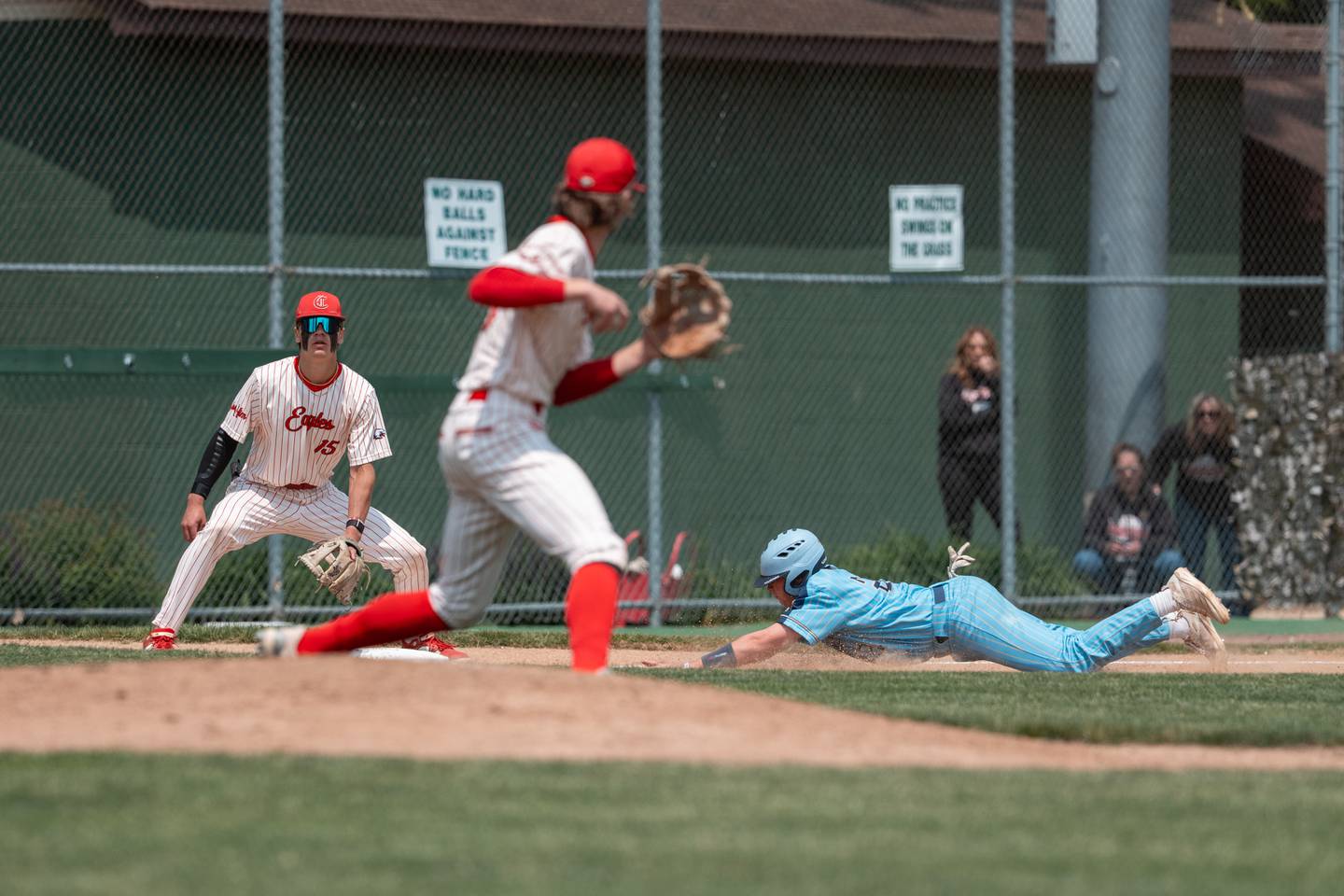 Marquette’s Anthony Couch (24) slides head first into 3rd Base as Aurora Christian 3rd Baseman Preston Morel (15) waits for the throw from the pitcher Trout Park in Elgin, IL on Saturday May 31st, 2025.  Both teams competed to take home the 1A Sectional Championship Trophy.  Final Score: Marquette 5, Aurora Christian 1