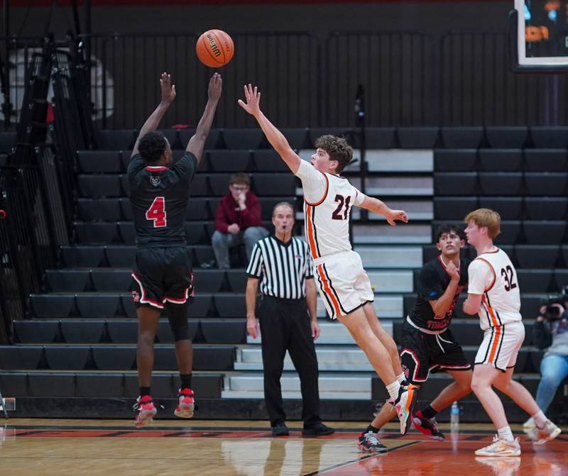 St. Charles East's Jacob Vrankovich (21) defends a shot by East Aurora's Kenneth Cooley (4) during the 64th annual Ron Johnson Thanksgiving Basketball Tournament at St. Charles East High School on Monday, Nov 20, 2023.