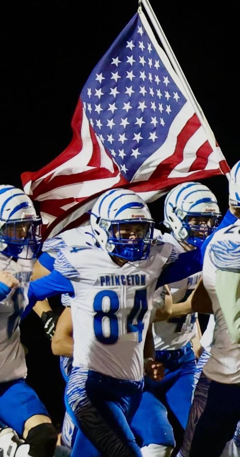 Newly signed Marine recruit Michael Kurth leads the Princeton Tigers out to Friday night at Prophetstown carrying the U.S. flag.