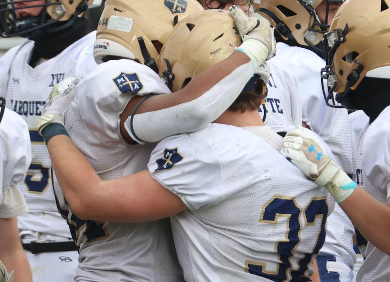 Marquette's Marcus Baker hugs teammate Grant Dose after loosing during the Class 1A playoff game on Saturday, Nov. 1, 2025 at Gibson City-Melvin-Sibley High School.