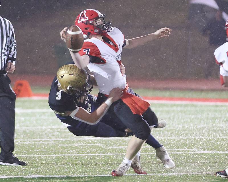 Amboy/LaMoille/Ohio quarterback Tanner Welch manages to get a throw off as Polo's Damon Rowe wraps him up during the 8-man I8FA championship game on Friday, Nov. 21, 2025 at April Zorn Memorial Stadium in Monmouth.