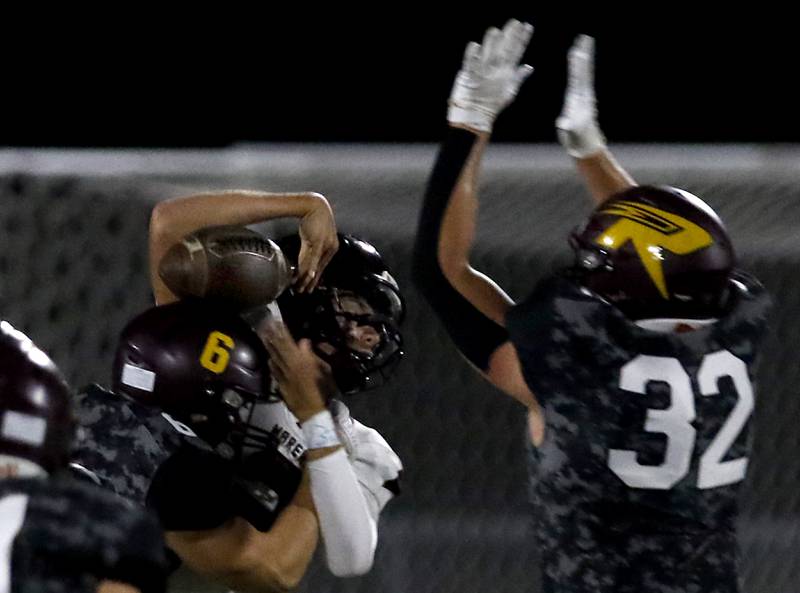 Richmond-Burton's Hunter Carley hits Marengo's Sam Vandello as he tries to pass over the pressure of Richmond-Burton's Breckin Campbell during a Kishwaukee River Conference football game on Friday, Oct. 17, 2025, at Richmond-Burton High School in Richmond.
