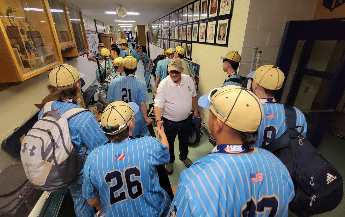 Marquette football coach Tom Jobst congratulates the Crusaders on their Class 1A baseball state championship on Saturday at Bader Gym.