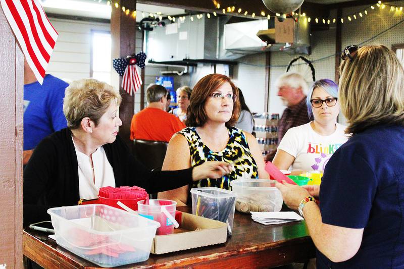Marion Younger (from left), Amy Dodge and Jacqueline Younger run the sales table for Queen of Hearts and 50-50 raffle tickets Sept. 5 at K's Korners in rural Sterling. Proceeds from both drawings benefits PADS Homeless Shelter in Dixon.