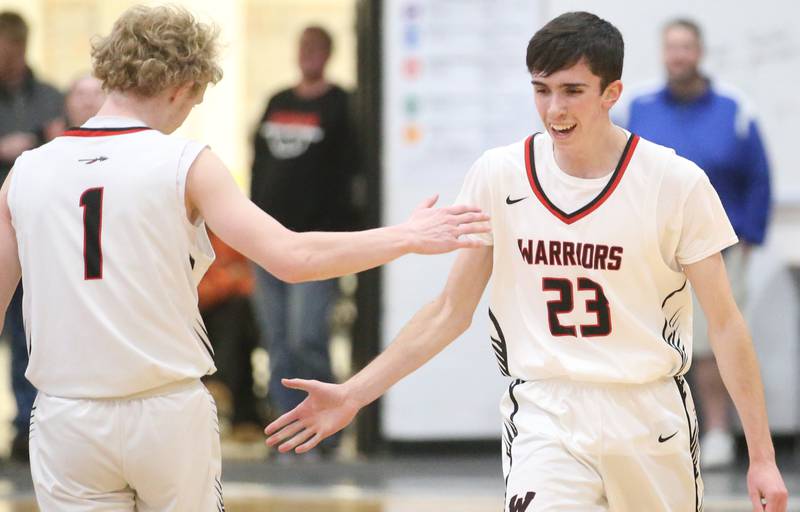 Woodland's Nick Plesko hi-fives teammate Connor Dodge after sinking a three at the buzzer to end the first half against Marquette during the Tri-County Conference Tournament on Tuesday, Jan. 28. 2025 at Putnam County High School.