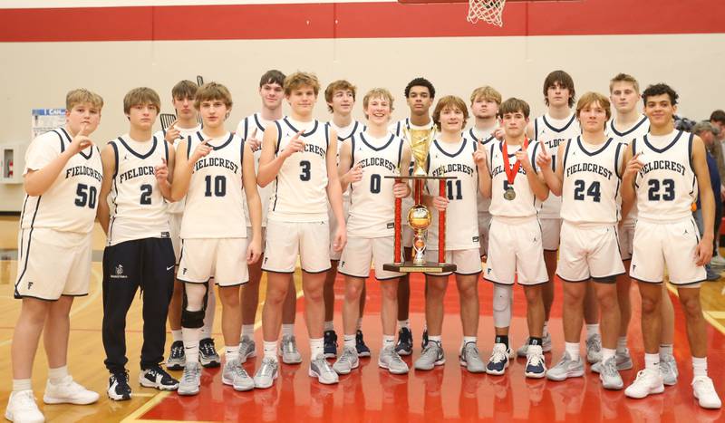 Members of the Fieldcrest basketball team pose with the Colmone Classic first place trophy after defeating Rock Falls in the 49th annual Colmone Classic on Saturday, Dec. 9, 2023 at Hall High School.