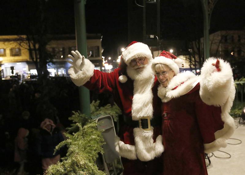 Santa and Mrs. Claus wave to the crown during the Lighting of the Square Friday, Nov. 29, 2024, in Woodstock. The annual holiday season event featured brass music, caroling, free doughnuts and cider, food trucks, festive selfie stations and shopping.