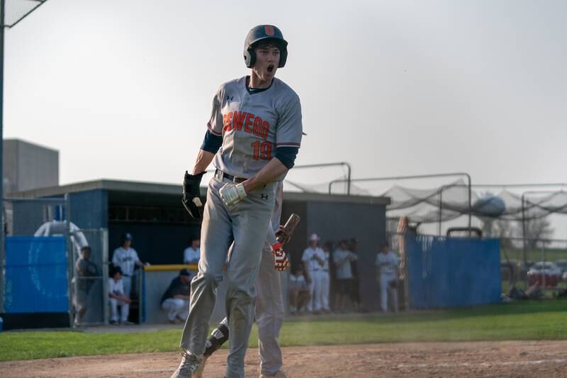 Oswego’s Luke Voelker (19) celebrates after scoring against Oswego East during a baseball game at Oswego East High School on Tuesday, May 10, 2022.