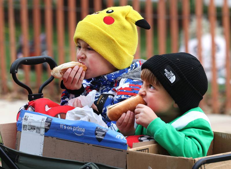 Graison Katz, (left) 7, and his brother Lucas, 5, from Sycamore, enjoy some hotdogs as they wait for the cake cutting Wednesday, Oct. 22, 2025, during opening day of the Sycamore Pumpkin Festival.