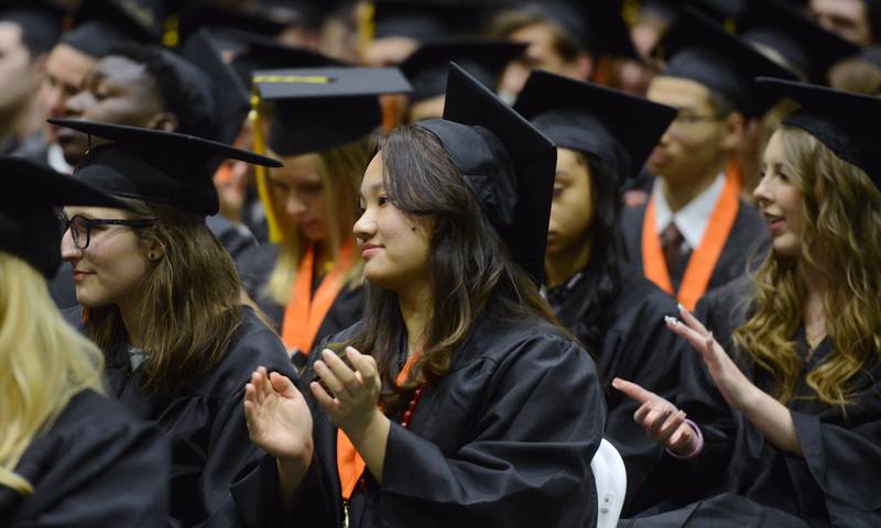 Joe Lewnard/jlewnard@dailyherald.com
Graduates give their applause following a speech during the Wheaton Warrenville South High School graduation, held at the College of Dupage in Glen Ellyn Saturday.