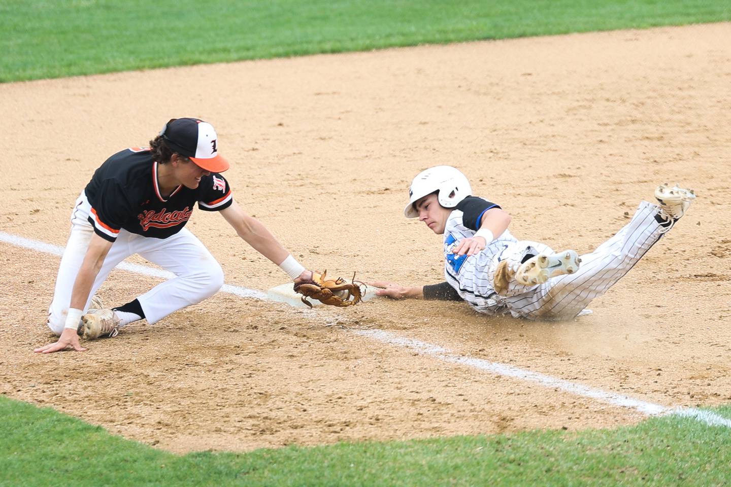 Lincoln-Way East’s Tyler Bell dives safely back to third against Libertyville on Saturday, May 13, 2023 in Frankfort.