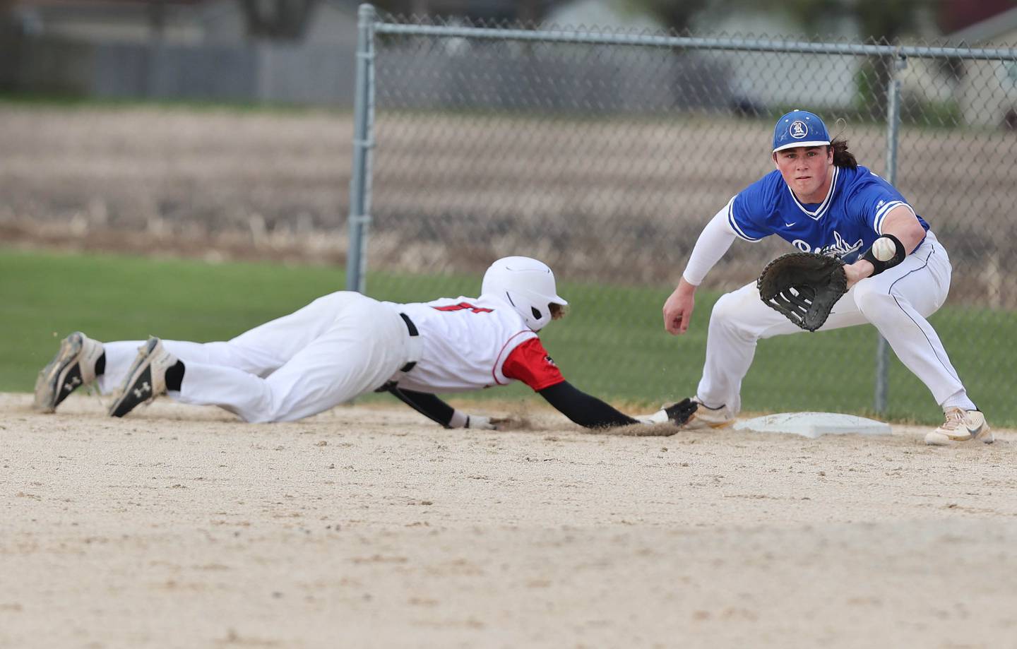 Indian Creek's Kason Murry dives back into first base as Hinckley-Big Rock's Martin Ledbetter takes the throw during their game Monday, May 1, 2023, at Indian Creek High School in Shabbona.