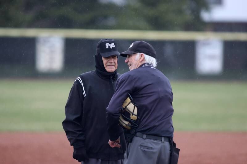 The umpiring crew suspends a game between Prairie Ridge and Jacobs in varsity baseball on Wednesday, April 9, 2025, at Prairie Ridge High School in Crystal Lake. Rains made the field unplayable.