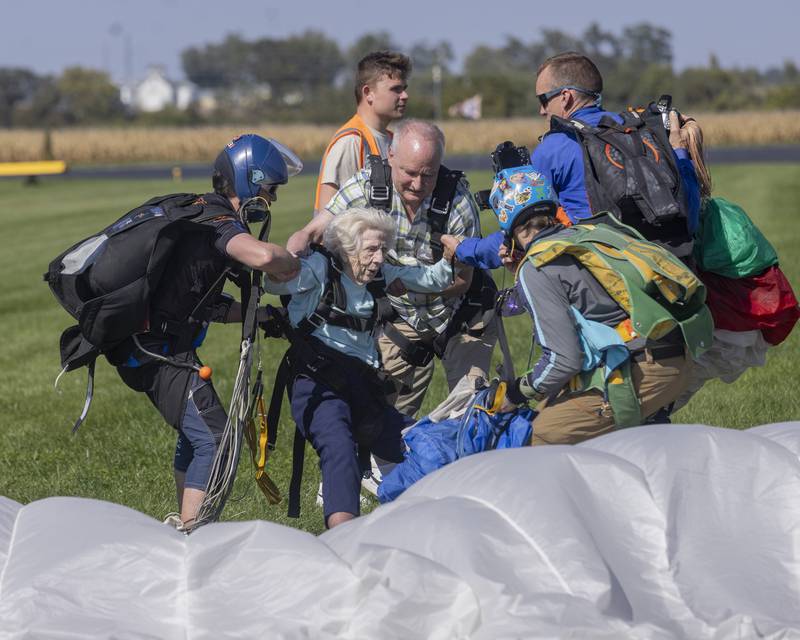 Fellow jumpers help record setting Dorothy Hoffner back onto her feet after the sliding landing on October 1, 2023.