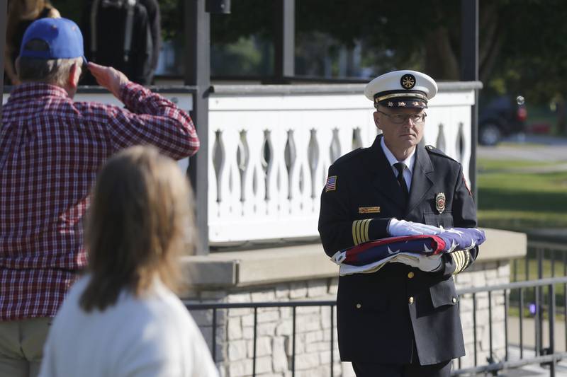 McHenry Township Fire Protection District Deputy Fire Chief Steve Spraker caries an American Flag that flew in New York to be raided to half staff during a September 11 Remembrance Ceremony on Sept. 11, 2025, at Veterans Park in McHenry.