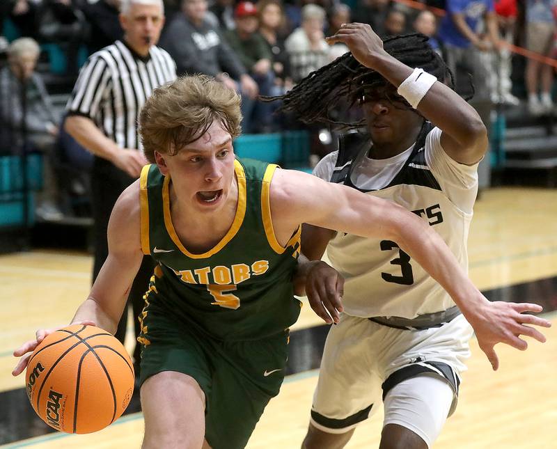 Crystal Lake South's Carson Trivellini drives the baseline against Kaneland's Marshawn Cocroft during the IHSA Class 3A Woodstock North Sectional final basketball game on Friday, March 6, 2026, at Woodstock North High School.