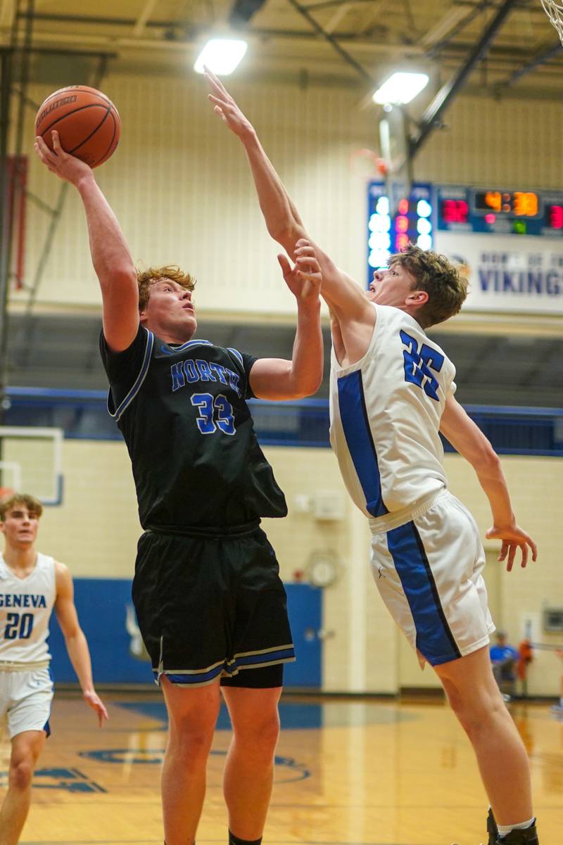 St. Charles North's Jake Furtney (33) shoots the ball in the post over Geneva’s Hudson Kirby (25) during a basketball game at Geneva High School on Wednesday, Feb 14, 2024.