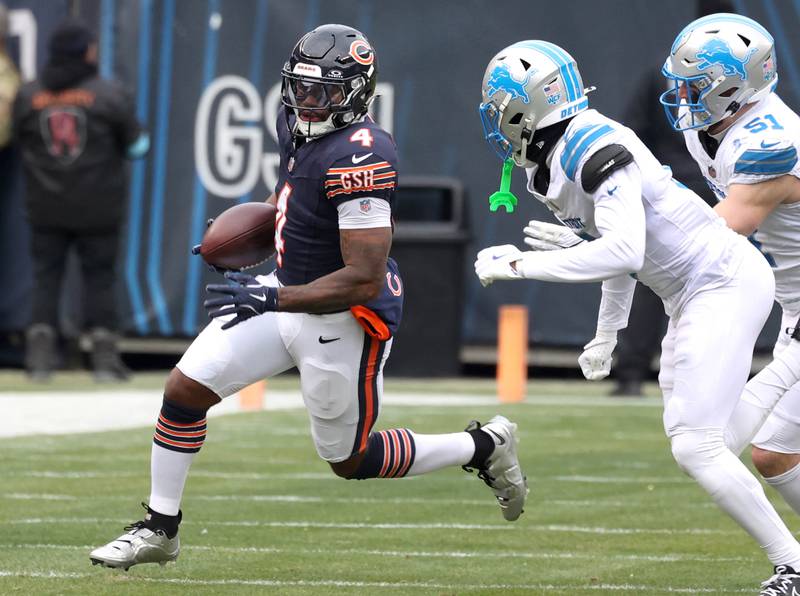 Chicago Bears running back D'Andre Swift tries to get outside of Detroit Lions cornerback Terrion Arnold and linebacker Ben Niemann during their game Sunday, Dec. 22, 2024, at Soldier Field in Chicago.