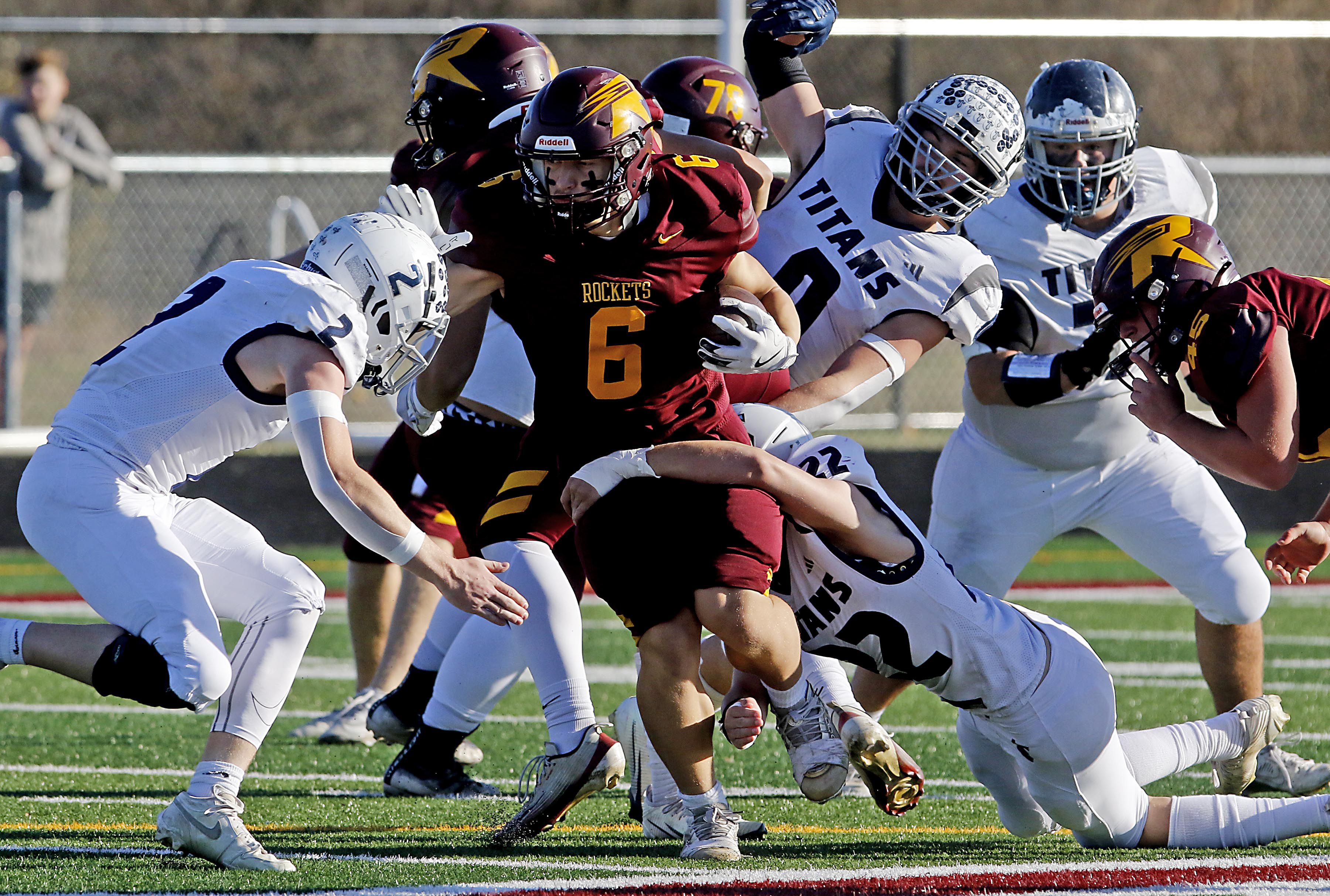 Richmond-Burton's Hunter Carley tries to run between Monmouth-Roseville's Andrew Way (left) and  Asa Braun (right) during an IHSA Class 3A quarterfinal playoff football game on Saturday, November 15, 2025, at Richmond-Burton High School, in Richmond.