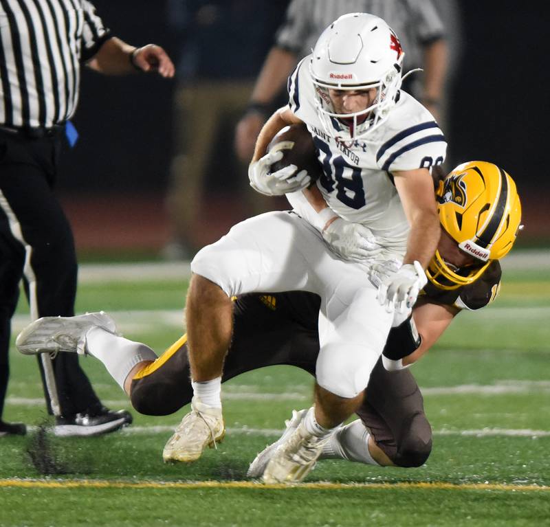 Joe Lewnard/jlewnard@dailyherald.com
St. Viator’s Luca Cutinello gets tackled by Carmel's Ryan Harris during Friday’s game in Mundelein.