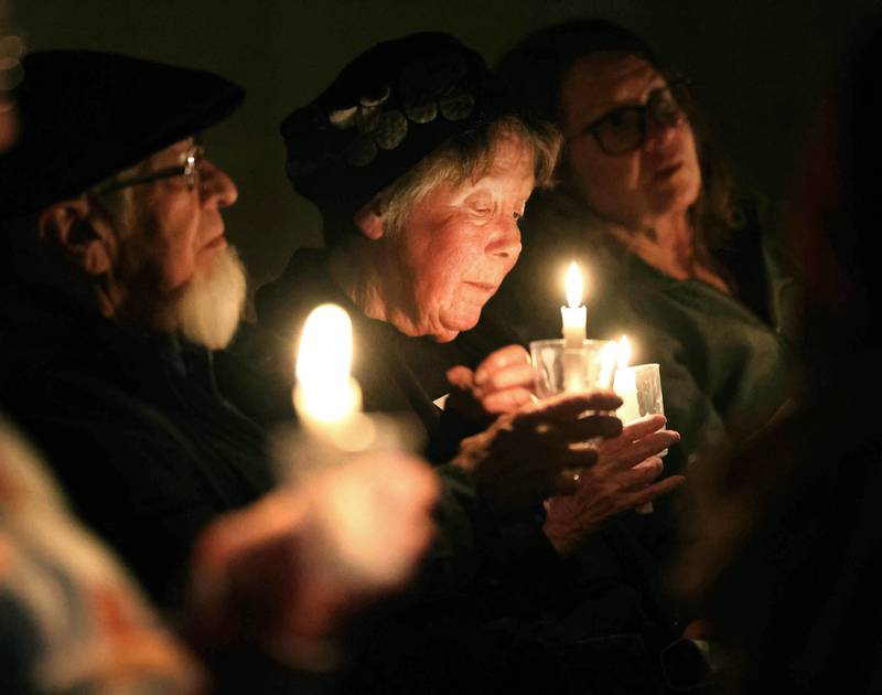 Visitors sit in quiet reflection while holding their candles Monday, Feb. 2, 2026, during the Vigil for Peace at the First Congregational United Church Of Christ in DeKalb. The vigil is being held in remembrance of those lost in recent ICE related shootings and to show solidarity with the people of Minnesota.
