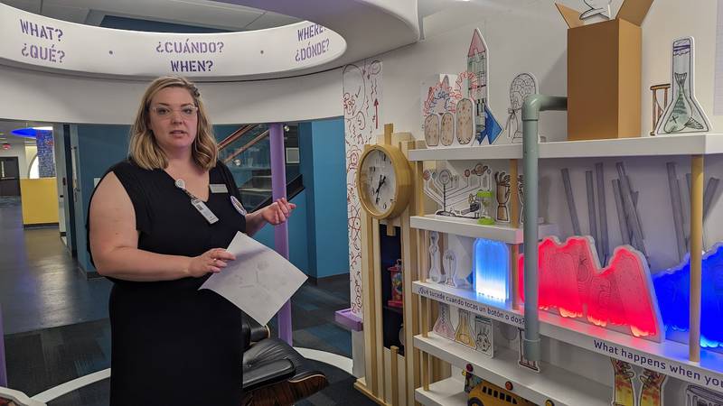 Mallory Hewlett, communications manager at the Joliet Public Library, shows one of the interactive displays in the “The Questioneers: Read. Question. Think. PLAY!” exhibit on Wednesday, June 21, 2023. This exhibit is based on the Questioneers book series authored by Andrea Beaty and illustrated by David Roberts. This traveling exhibit featuring the Questioneers characters opened June 16 at the Ottawa Street branch of the Joliet Public Library and is available during library hours through July 29.