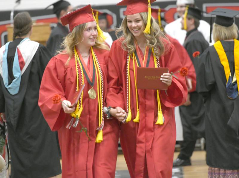 Autumn McGlynn and Taylor Akins share a smile as they exit the Forreston High School gym following commencement on Sunday.