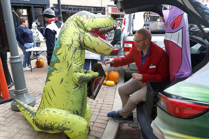 Kaleb Price, from the Woodstock Area Chamber of Commerce and Industry, hands out candy to trick or treaters during Halloween on the Square on Thursday, Oct. 31, 2024, in Woodstock. The event featured trick and treating and a costume contest.