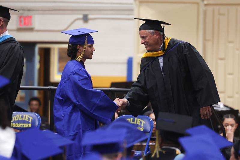 A graduate receives their diploma at the Joliet Central Class of 2023 Commencement Ceremony on Saturday, May 20, 2023, in Joliet.