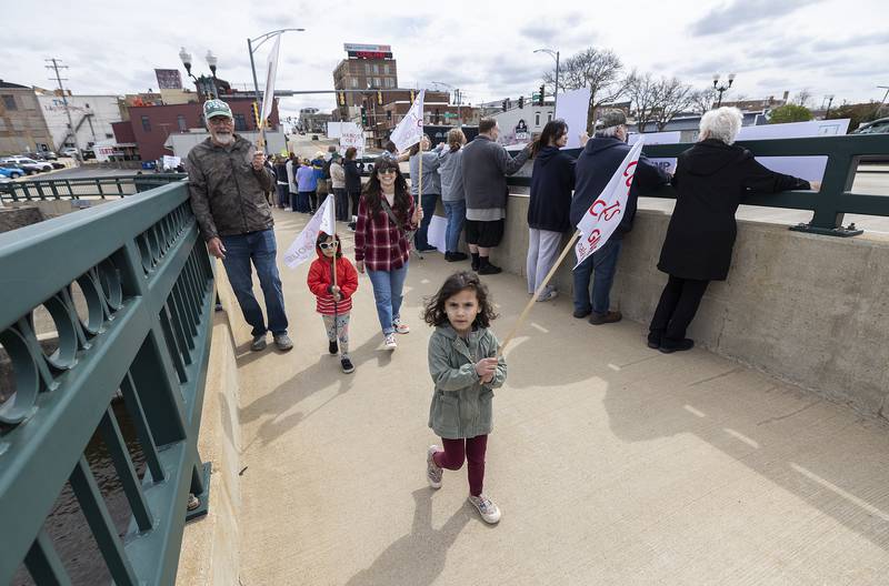 Bree Hartman, 4, leads her family, twin sister Rae, mom Nadine and Myron Alderks during a Hands Off rally in Dixon Saturday, April 19, 2025. The group lined the edges of the Galena Avenue bridge voicing their opinion of President Trump and their feelings the administration is not following a Democracy based government.