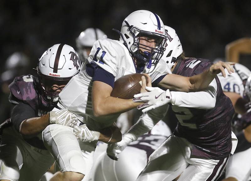 Cary-Grove's Peyton Seaburg tries to break the tackle of Prairie Ridge's Andrew Koeppen (left)  and Logan Thennes (right) during a Fox Valley Conference football game on Friday, Sept. 27, 2024, at Prairie Ridge High School.