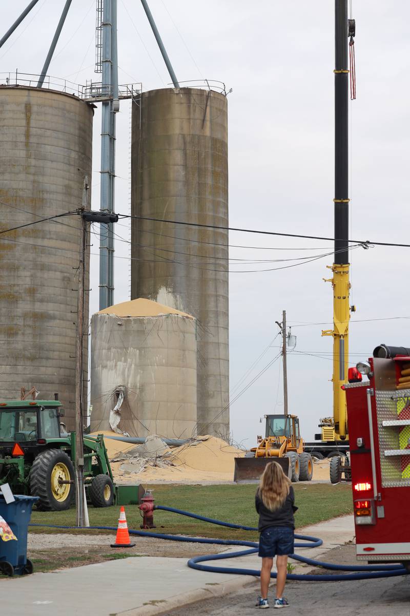 A bystander exited a nearby business to observe the damage following a concrete grain bin collapse on Wednesday, Oct. 15, 2025, at the Donovan Farmers Co-Op Elevator in downtown Martinton.