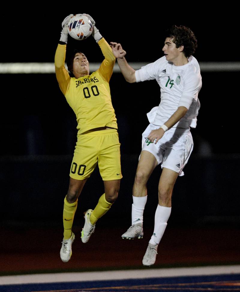 Drew Ebner Romeoville goalkeeper Carlos Escobar stops a York shot as York’s Drew Ebner gets in position for a rebound  in the Class 3A semifinal game of the boys state soccer tournament in Hoffman Estates on Friday, November, 4, 2022.