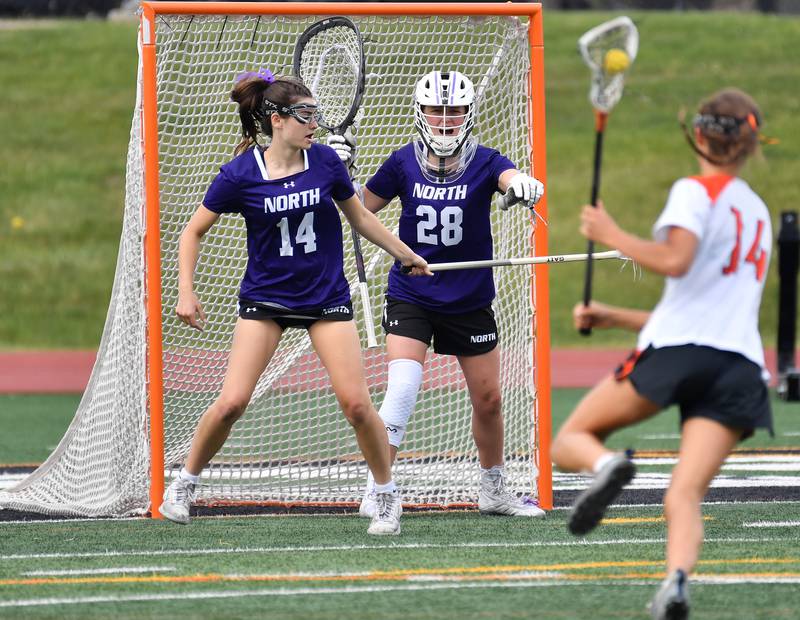 Downers Grove North goalkeeper Natalie Giannelli (28) directs attention to to the attack of Crystal Lake’s Addie Bechler (right) as teammate Meghan Southworth helps her defend the goal during the Benet Supersectional game on June 3, 2025 at College of DuPage in Glen Ellyn.