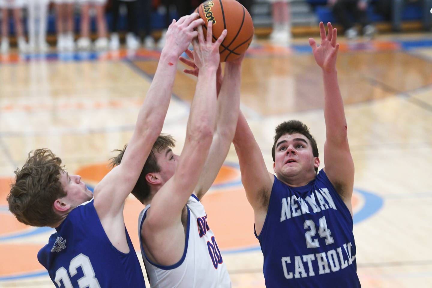 Eastland's Kellen Henze (center) battles and Newman's Lucas Simpson (left) and Ethan Van Lunduit for a rebound during semi-final action at the 1A Eastland Regional.