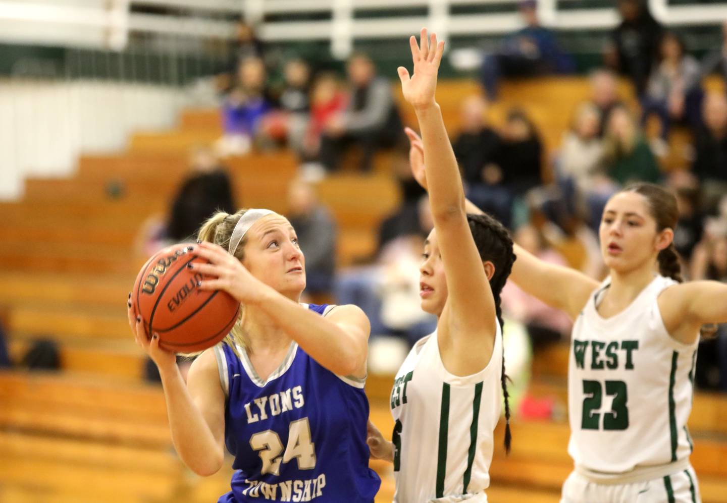 Lyons Township’s Kennedy Wanless (left) looks for an opening past Glenbard West’s Lauren Escalante during a game in Glen Ellyn on Tuesday, Dec. 12, 2023.