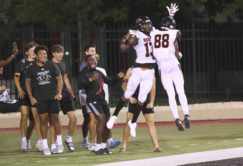 DeKalb’s Davon Grant (left) celebrates with Derrion Straughter after Grant scored a touchdown late in the first half during the First National Challenge game Friday, Aug. 25, 2023, in Huskie Stadium at Northern Illinois University in DeKalb.
